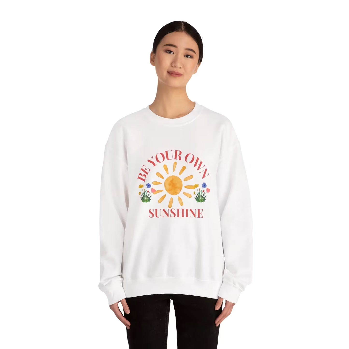 Person wearing a white sweatshirt with a sun graphic and text on a white background