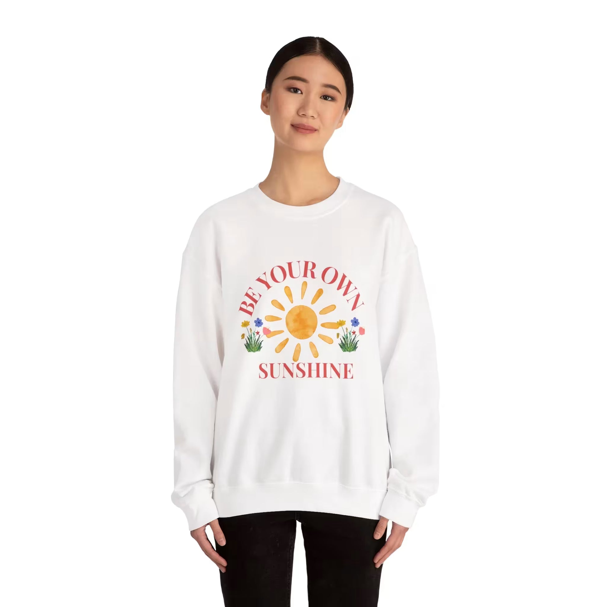 Person wearing a white sweatshirt with a sun graphic and text on a white background